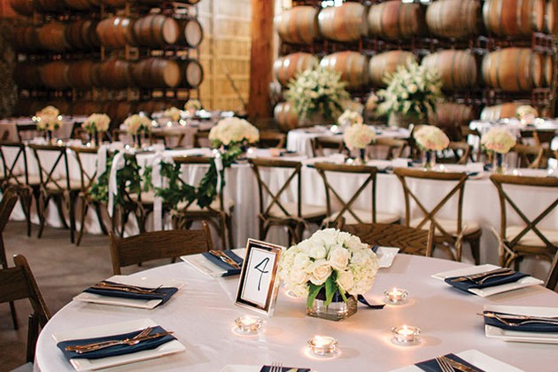 Elegant wedding reception table setup with floral centerpieces and candles at Maysara Events.